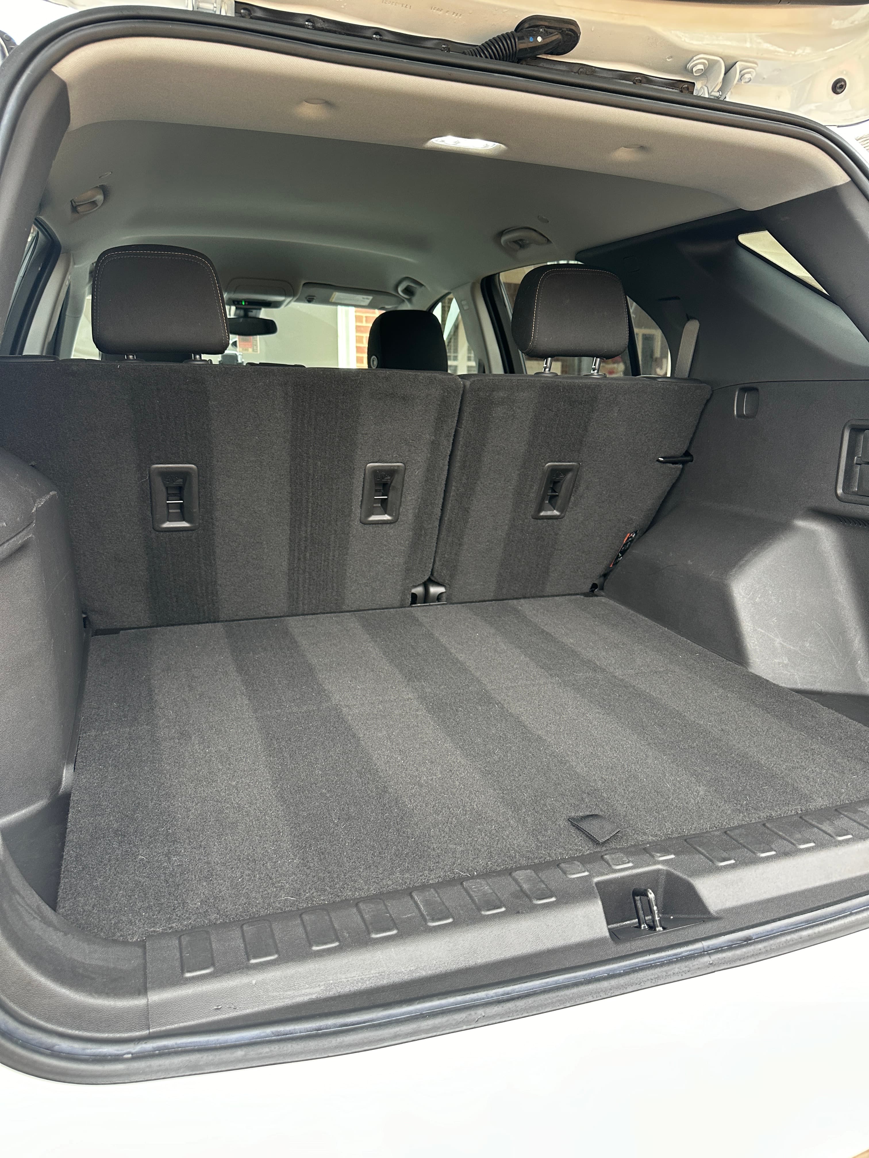 Spacious, freshly vacuumed cargo area of a vehicle with the rear seats folded flat.