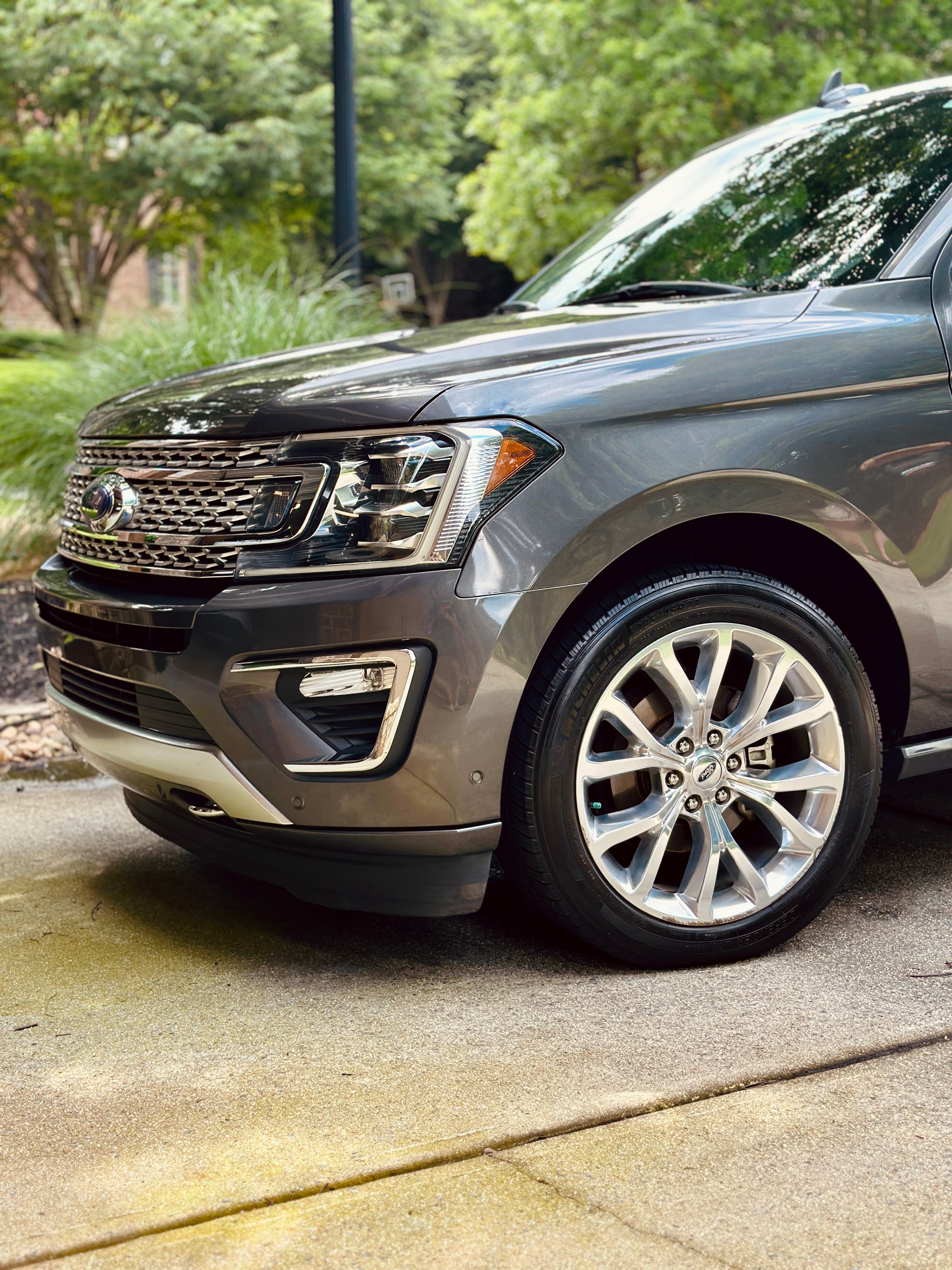Front view of a dark gray Ford Expedition SUV featuring chrome accents and wheels.